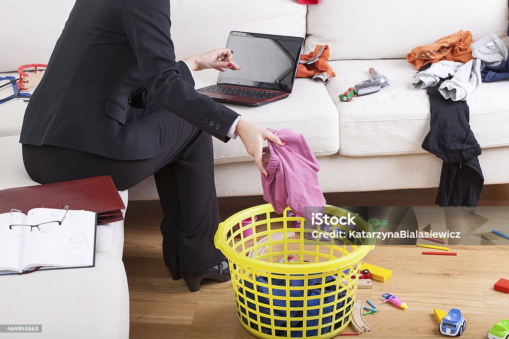 Active woman cleaning house and working Active businesswoman cleaning house and working on computer in the same time Working Mother Stock Photo