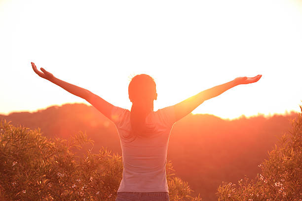istock woman raised arms to sunrise 464953113