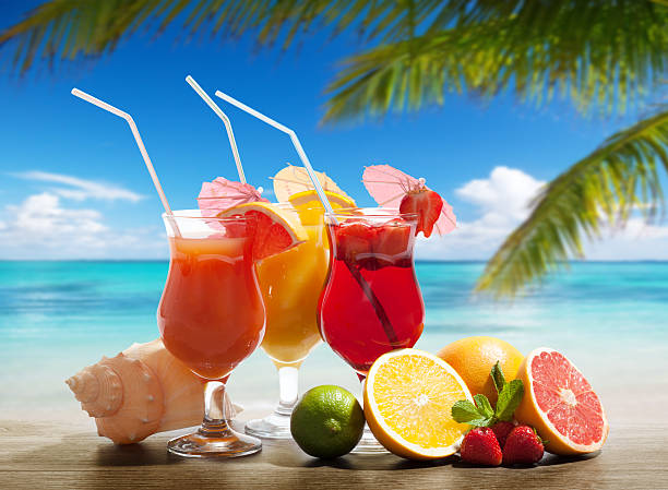 istock Cocktails and tropical fruit displayed on the beach 464954398