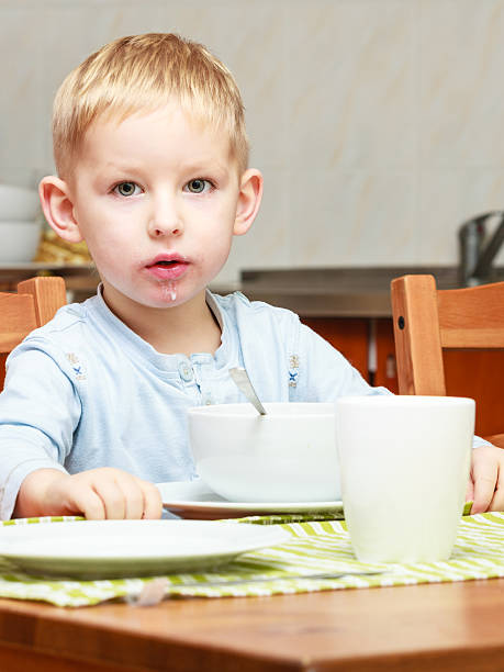 istock Boy kid child eating corn flakes breakfast at the table 464957223