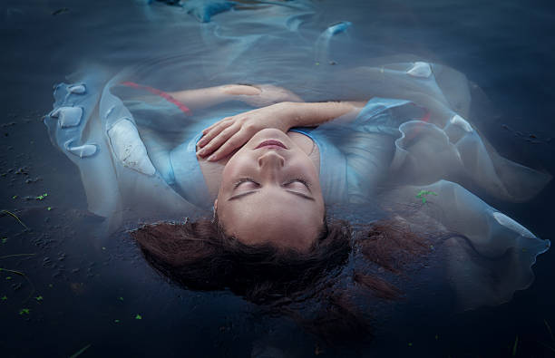 istock Young beautiful drowned woman lying in the water 464958836