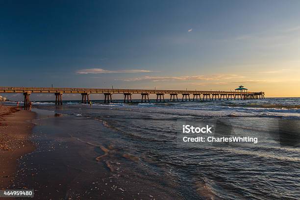 Fishing Pier At Sunrise With Blue Sky And White Clouds Stock Photo - Download Image Now