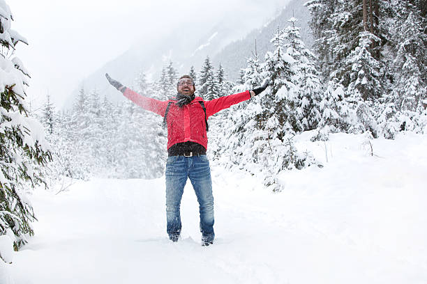 istock Happy young man with snow glasses throws up snow 464959482