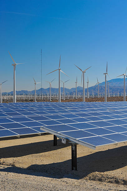 istock Solar panels in front of wind turbines and mountians 464962991