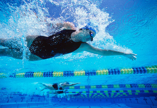 istock Professional female swimmers swimming in pool 464963593