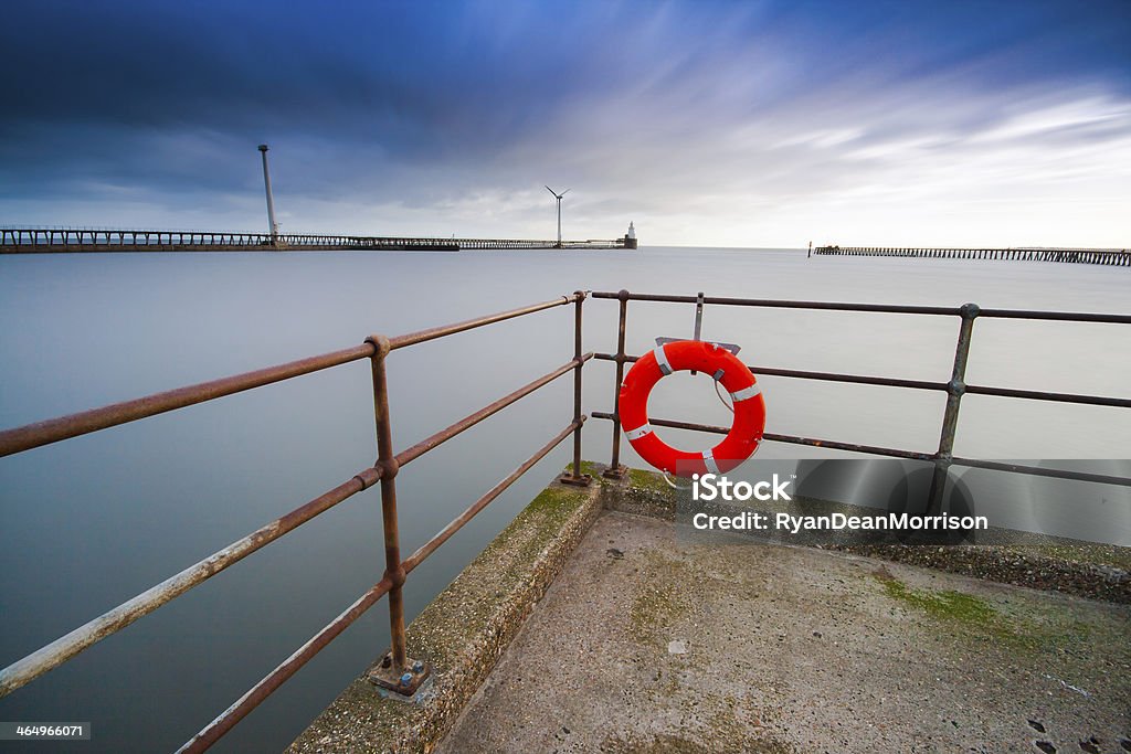 Blyth Waterfront. A windy day at Blyth with wind turbines in the distance. Long exposure shot with misty water. Life Belt Stock Photo