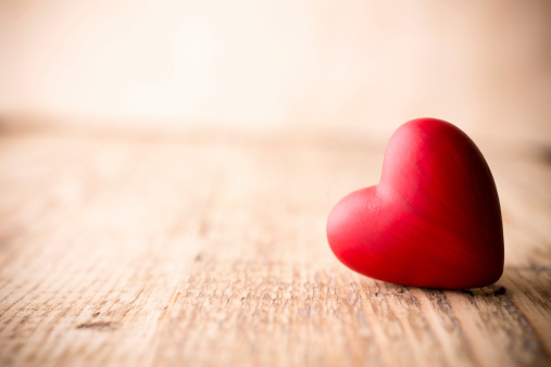 Red heart-shaped candy on a wooden background.