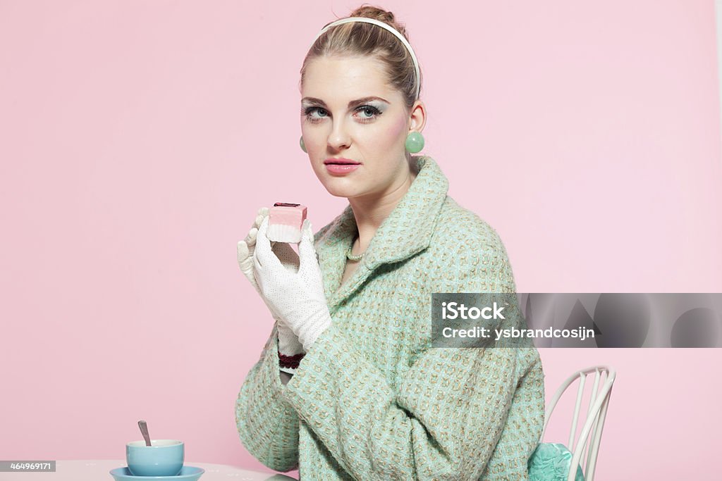 Girl blonde hair fifties fashion style eating cup cake. 1950-1959 Stock Photo