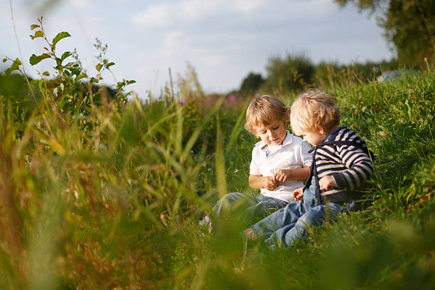 istock Two little brother boys playing near forest lake 464973127