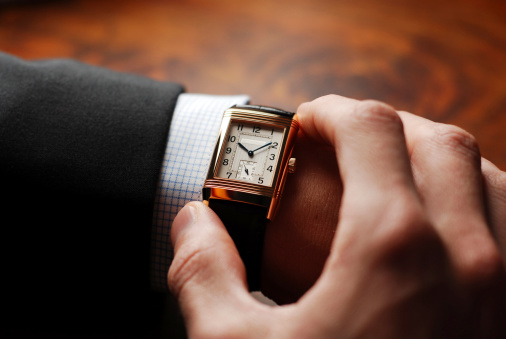 Businessman checking his wristwatch - nice shot over the shoulder. It's time to go to the next appointment.