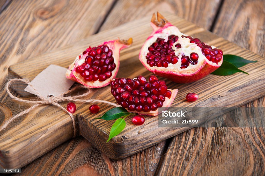 pomegranate Juicy pomegranate and red grains on wooden background 2015 Stock Photo