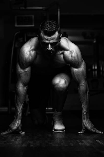 força muscular homem ajoelhado no chão - human muscle body building exercising black and white - fotografias e filmes do acervo