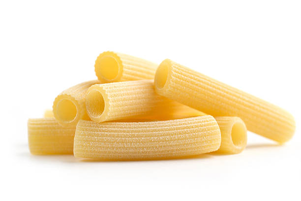 italian pasta heap of tubular pasta on white background rigatoni stock pictures, royalty-free photos & images