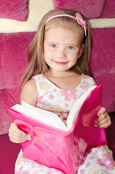 istock Cute smiling little girl reading a book 464983519