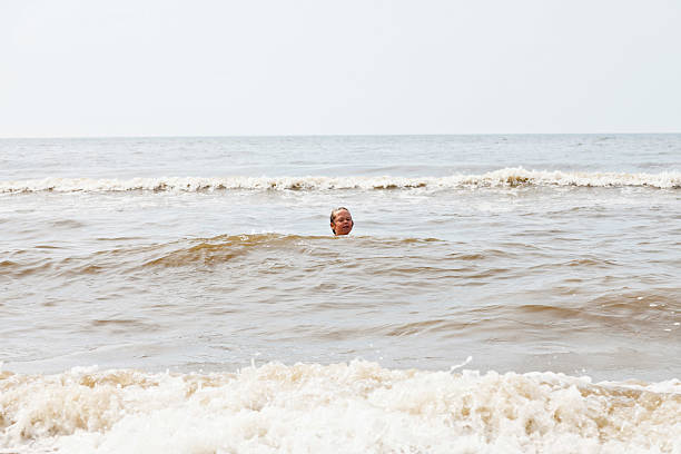 istock Young boy swimming in sea. Enjoying the waves. 464984175