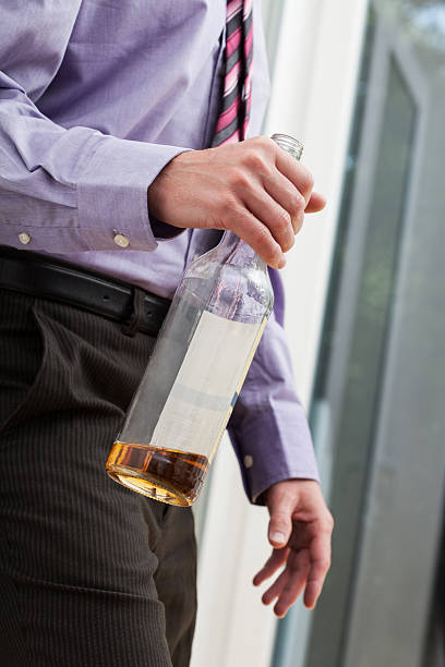 istock Drunk businessman holding a bottle 464987605