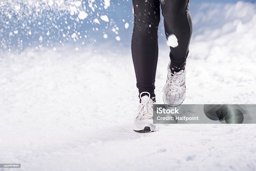Winter running woman Athlete woman is running during winter training outside in cold snow weather. Active Lifestyle Stock Photo