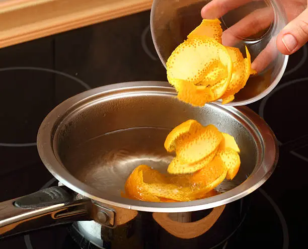 Photo of Add orange peel into saucepan with boiling syrup