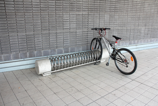 Metal spiral holder for bikes set up in front of retail store