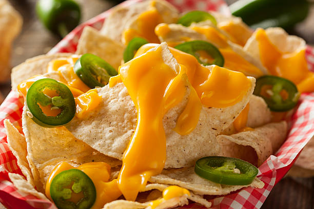 Homemade Nachos with Cheddar Cheese Homemade Nachos with Cheddar Cheese and Jalapenos nacho chip stock pictures, royalty-free photos & images