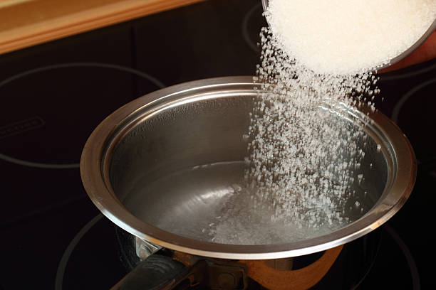 istock Pouring sugar into saucepan with boiling water 464996451