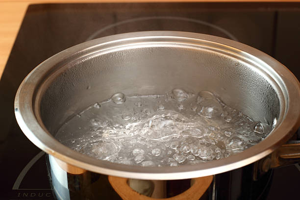 istock Stainless pot with water boiling inside on a stove-top 464996511