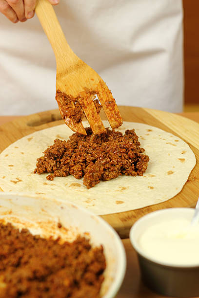 istock Putting portion of stuffing (ground beef) on tortillas 464998059