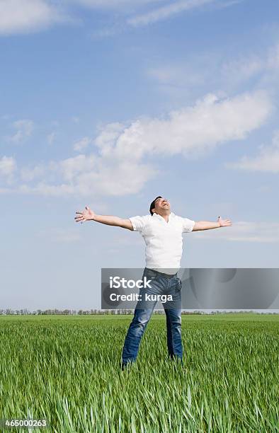 Young Man Moves In A Green Field Of Grass Stock Photo - Download Image Now - Activity, Adult, Agricultural Field