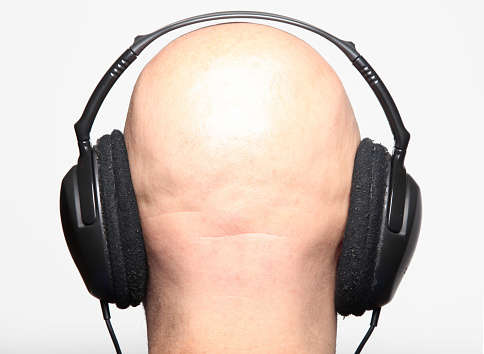 Bald man wearing Headphones.