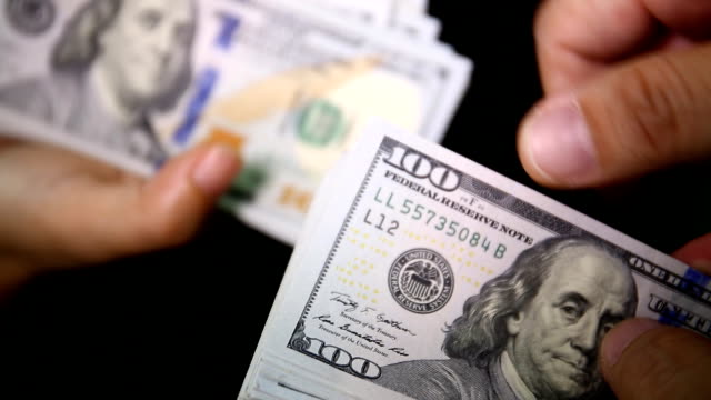 Close up of paying cash from man's hands counting