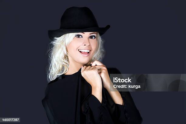 Blonde Fashion Woman Portrait Wearing Black Hat Over Dark Stock Photo - Download Image Now