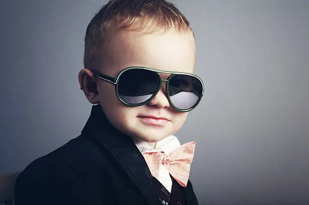 Photo of Young boy dressed as a gentleman with sunglasses