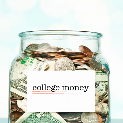 Money jar filled with American cash marked for college fund