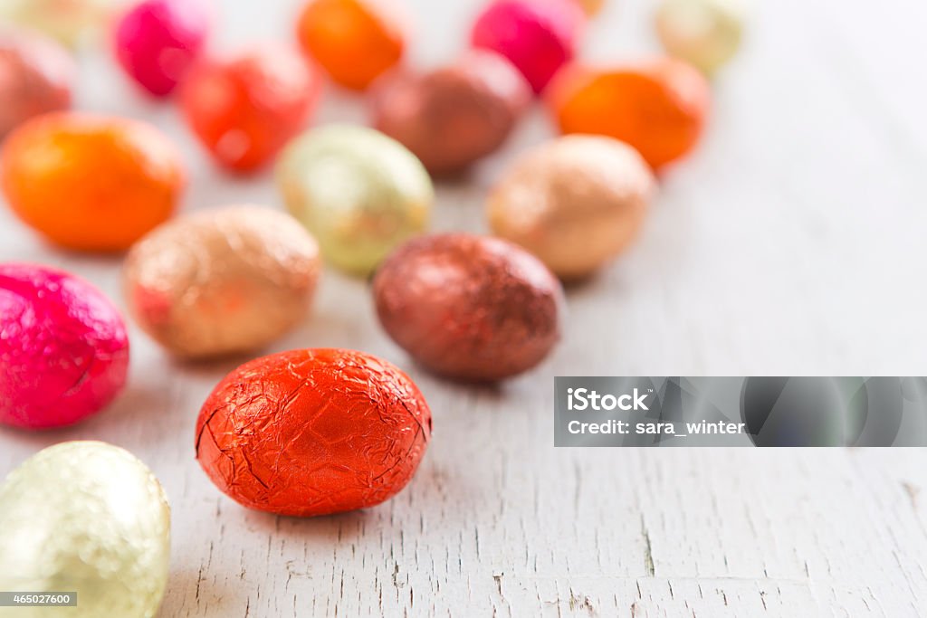 Small chocolate Easter eggs on a rustic white background Assortment of chocolate Easter eggs on a rustic background. Candy Stock Photo