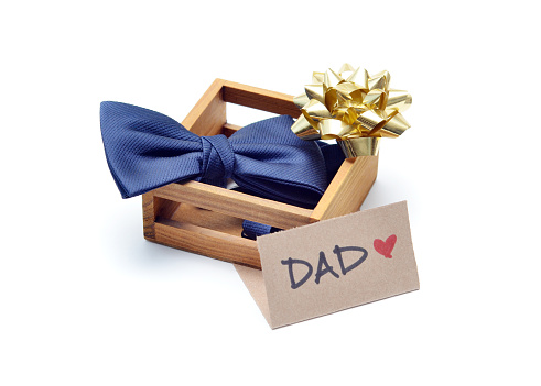 Closeup of a bow tie in a wood box with bow symbolizing a Father's Day gift.  