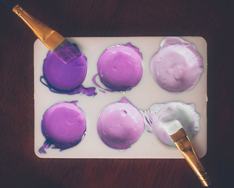 Paint palette with paint colors in various shades of purple