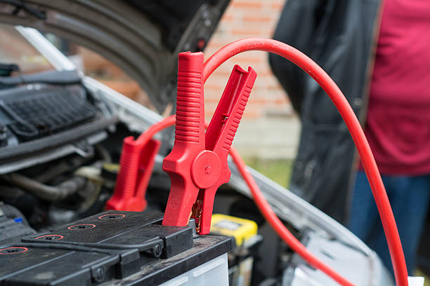 car battery charging car battery clamped with red  jumper cable to recharge the power 12v stock pictures, royalty-free photos & images