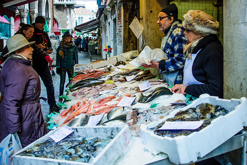 Venice, Italy - February 3, 2015:  Market scene with sellers and shoppers in the rialto market, in Venice, Veneto, Italy