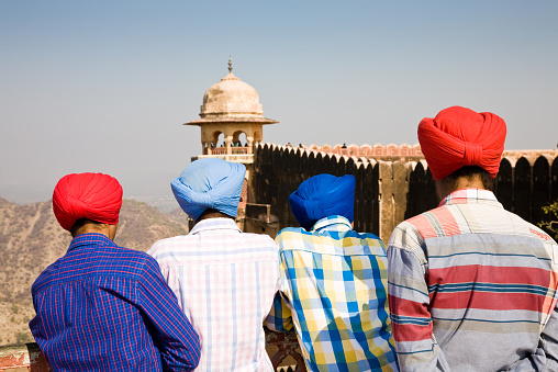Amber, India - 2014, December 30 : Four Sikh male tourists in the Amber fort near Jaipur in Rajasthan enjoying the view from the walls, India