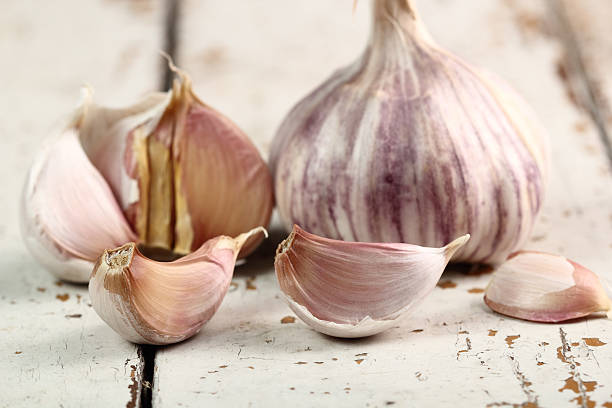 istock Garlic bulbs and cloves on peeling paint plank table 465040593