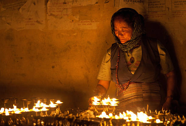 tibetan woman lights incense butter candles - losar bildbanksfoton och bilder
