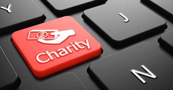 Charity with Money in the Hand Icon - Red Button on Black Computer Keyboard.