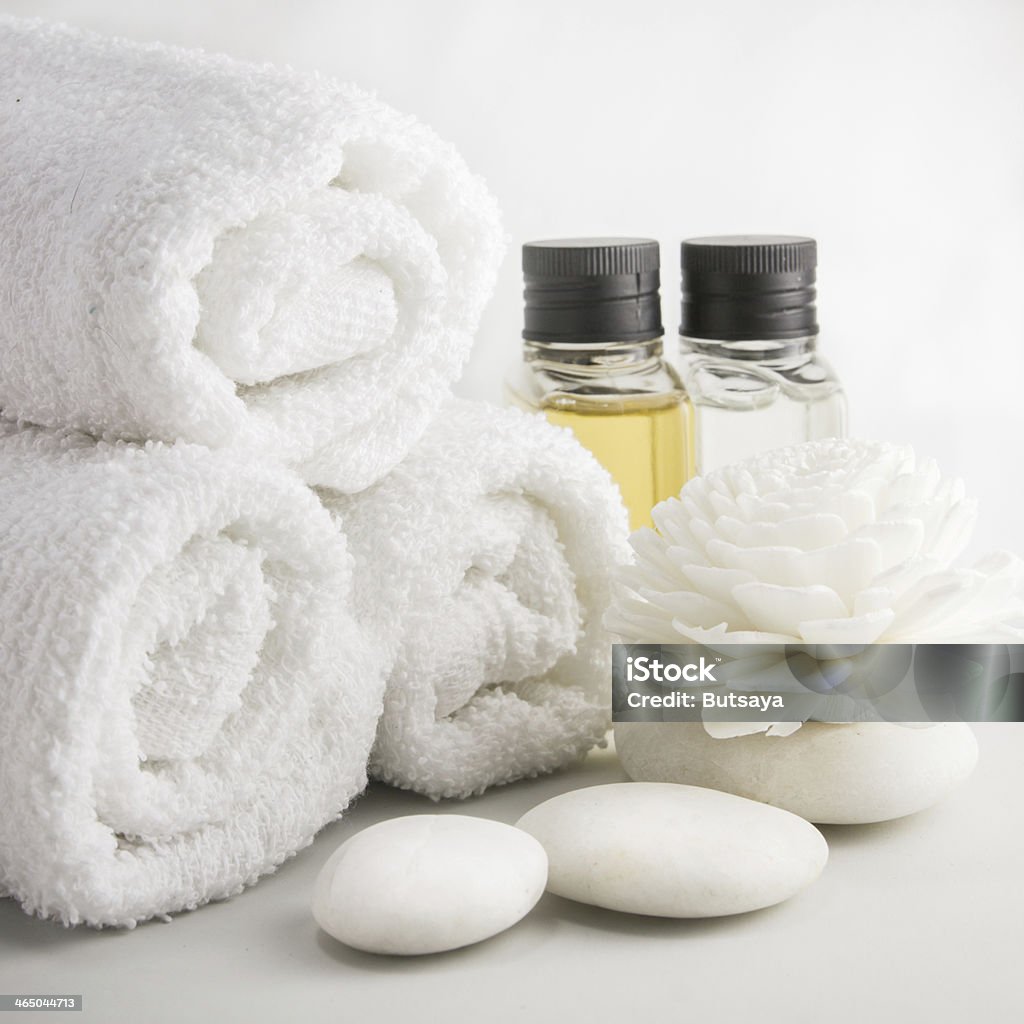 Spa setting with towels in bath room Spa setting with towels aroma oil bottles and hand made flower. Alternative Therapy Stock Photo