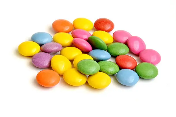 Pile of colored smarties on white background