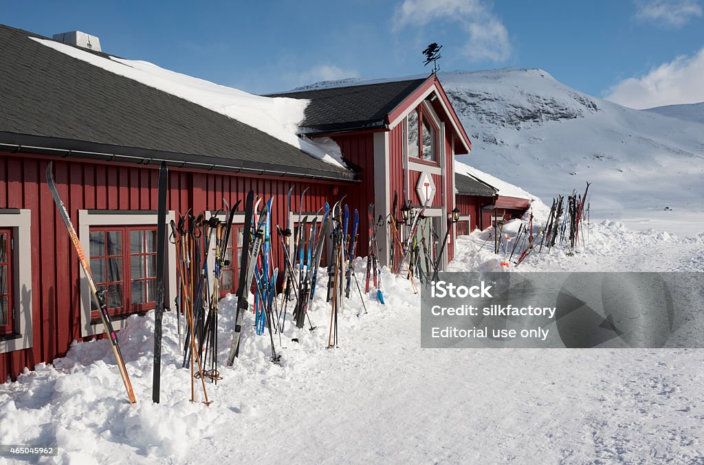 Cross-country skis outside mountain resort in Jotunheimen Jotunheimen, Norway - April 15, 2014: Many pairs of cross-country skis are parked at the entrance of a mountain resort (Fondsbu) - waiting for their owners to finish breakfast and head for the ski trails. 2015 Stock Photo