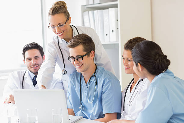 istock Smiling doctors and nurses discussing over laptop 465046280