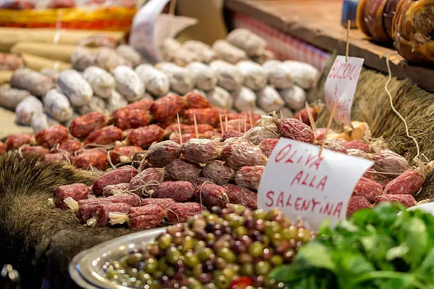 Italian market stall with wild boar salami and olives