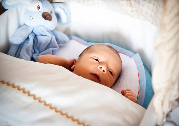 Newborn cute baby boy lying in bed