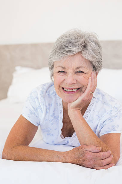 istock Happy senior woman lying in bed 465049476