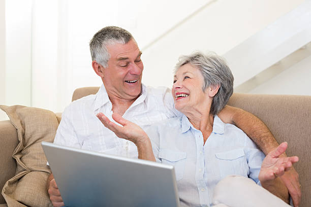 istock Loving senior couple with laptop on sofa 465050172